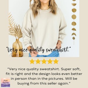 May include: A beige sweatshirt with the text "Very nice quality sweatshirt." The image also includes a decorative vase with dried plants, a gold-colored wall hanging, and customer feedback with five gold stars.