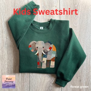 May include: A forest green children's sweatshirt with an elephant design made of patchwork. The words "Kids Sweatshirt" are in red. The Print Journey Shop logo is in the lower left corner. The words "forest green" are in the lower right corner.