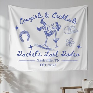 K&ouml;nnte beinhalten: Wei&szlig;e Wandbeh&auml;nge mit blauem Text und Illustrationen. Der Text lautet "Cowgirls & Cocktails Rachel's Last Rodeo Nashville, TN EST. 2025". Die Illustration zeigt eine Frau in einem Cowboyhut und Stiefeln, die in einem Martini-Glas sitzt.