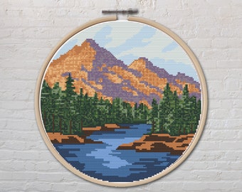 May include: A cross-stitch embroidery of a mountain landscape with a river flowing through it. The mountains are purple and orange, and the river is blue. There are green trees surrounding the river.