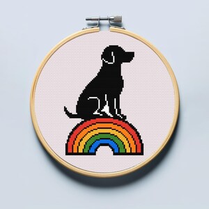 Puede incluir: Silueta negra de un perro sentado en un arcoíris. El arcoíris está hecho de rojo, naranja, amarillo, verde, azul, añil y violeta.