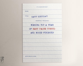 May include: A white card with blue lines, resembling a notebook page, with the text "IT'S YOUR BIRTHDAY" at the top. The text "HAPPY BIRTHDAY!" is in blue, and the text "WISHING YOU A YEAR OF MANY PAGES TURNED AND BOOKS FINISHED!" is in red and blue. The card has the text "DEAR:", "TITLE:", and "HEARTFELT MESSAGE:" in blue.