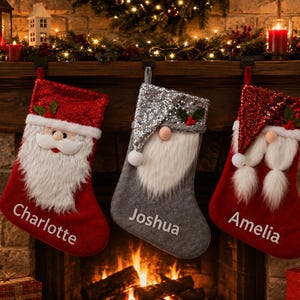 May include: Three Christmas stockings hanging in a row. The left is red with a sequined cuff and a Santa face. The centre is grey with a silver sequined hat and a gnome face. The right is red with a sequined cuff and a gnome face. Names Charlotte, Joshua, and Amelia are embroidered on each.
