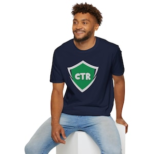 Op de afbeelding: Een marineblauw t-shirt met een groen schildlogo met de letters "CTR" in wit.