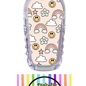 May include: A pink and white patterned sticker with rainbows, clouds, stars, and smiley faces. The sticker is designed to fit a medical device. The sticker is labeled "Diabetic Decor by Danica".