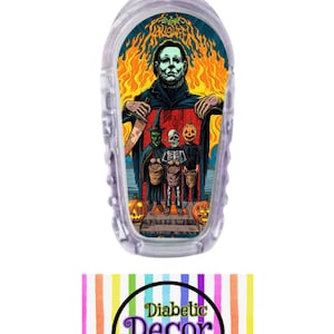 May include: A clear plastic medical device with a colorful sticker featuring a Halloween themed illustration of Michael Myers from the movie Halloween. The illustration includes a witch, a skeleton, and a pumpkin. The sticker has the text "Halloween Kills" on it.