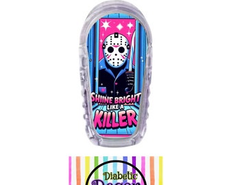 May include: A clear plastic medical device cover with a colorful graphic of a masked figure holding a knife. The graphic says "Shine Bright Like A Killer". The cover is for a diabetic device and is sold by Diabetic Decor.
