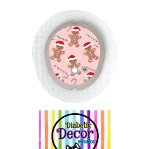 May include: A pink and white round sticker with a gingerbread man design. The sticker has a white border and a small hole in the center. The sticker is for a diabetic pump or continuous glucose monitor. The text "Diabetic Decor by Danica" is on a rainbow striped background.