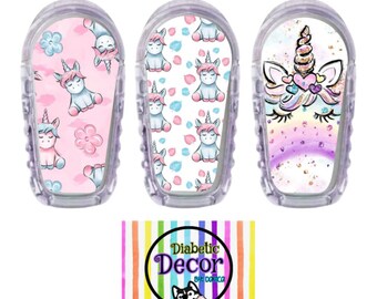 May include: Three colorful unicorn-themed stickers for a continuous glucose monitor (CGM). The stickers feature a pink and white unicorn pattern, a white and blue unicorn pattern, and a single unicorn with a rainbow and glitter design. The stickers are designed to be used on a CGM device.
