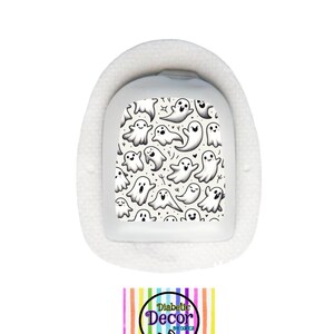 May include: White medical device with a cream-colored sticker featuring a repeating pattern of black cartoon ghosts. The sticker has the text "Diabetic Decor by Danica".