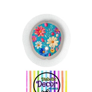 May include: A round, white, adhesive patch with a colorful floral design on a blue background. The design features pink, yellow, and white flowers with green leaves. The text "Diabetic Decor by Danica" is on a rainbow striped background with a cartoon husky dog.