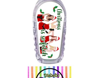 May include: A white medical device cover with a Christmas-themed design featuring a group of women in Santa hats and the text "Christmas is so fetch". The cover is made by Diabetic Decor by Danica.