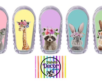 May include: Five colorful adhesive stickers featuring different animals wearing flower crowns. The animals are a koala, giraffe, raccoon, bunny, and bunny. The stickers are designed for use on medical devices. The stickers are from Diabetic Decor by Doxica.