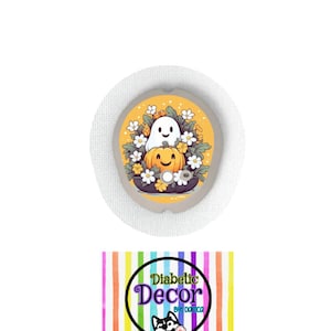 May include: A round, white medical patch with a colorful design featuring a ghost and a pumpkin with flowers. The text "Diabetic Decor by: Danica" is on a rainbow striped background.