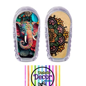 May include: Two colorful adhesive covers for a continuous glucose monitor (CGM). One cover features a mandala design with shades of green, yellow, orange, and purple. The other cover features a colorful illustration of an elephant with intricate details. Both covers are designed to be applied to the CGM device. The text "Diabetic Decor by Danica" is visible in the lower right corner of the image.