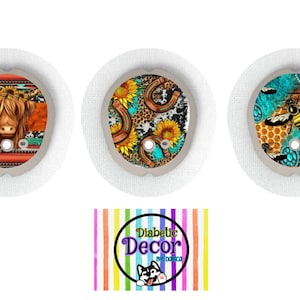 May include: Three round adhesive patches with colorful designs. The first patch features a Highland cow with a floral crown, the second patch features a turquoise horseshoe, leopard print, and sunflowers, and the third patch features a bee with honeycomb and turquoise accents. The text "Diabetic Decor by Dolca" is printed on a colorful striped background.