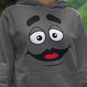 May include: A charcoal gray hoodie with a large cartoon face printed on the front. The face has a big smile, large eyes, and a mustache.