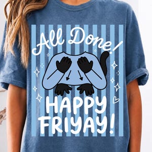 Puede incluir: Una camiseta azul con un estampado gráfico de rayas verticales azul claro. El diseño incluye un personaje de dibujos animados con manos y cola negras, rodeado de estrellas blancas y el texto "All Done! HAPPY FRIYAY!" en letra blanca.