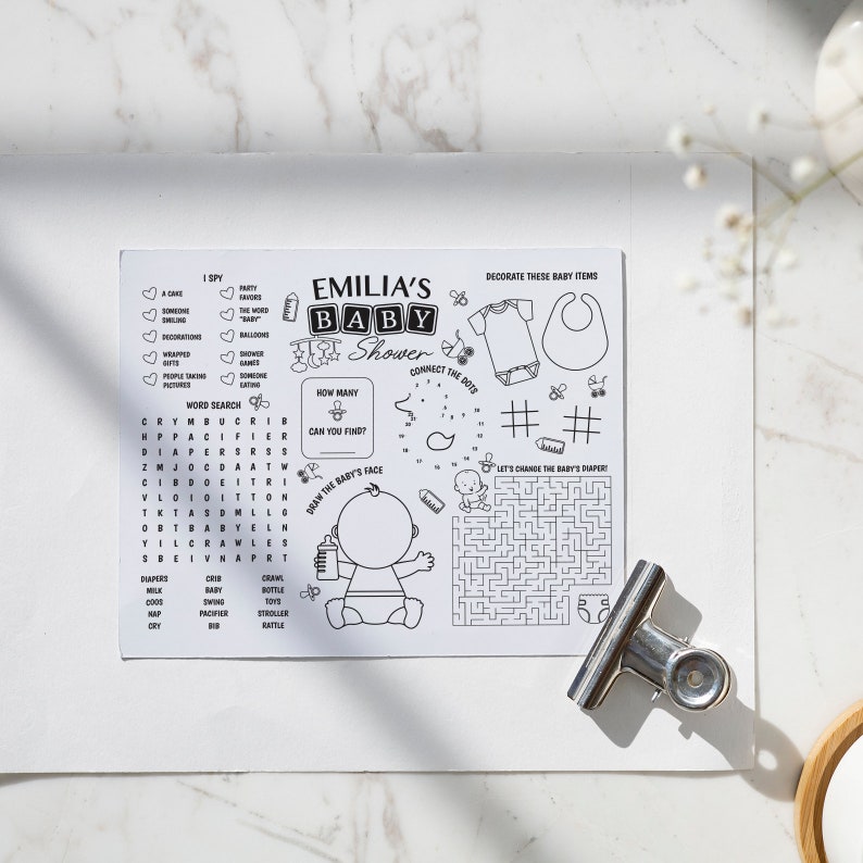 K&ouml;nnte beinhalten: Schwarzwei&szlig;es druckbares Babyparty-Spiel mit Aktivit&auml;ten wie Punkte verbinden, Wortsuche und einem Labyrinth. Das Spiel zeigt ein Baby mit einer Flasche und den Text "Emilia's Baby Shower".