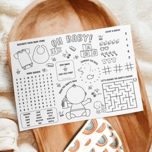May include: A black and white printable activity sheet for children with the words "Oh Baby!" at the top. The sheet includes a word search, connect the dots, count and match, and a maze. The sheet is designed for a baby shower or a new baby.