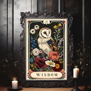 K&ouml;nnte beinhalten: Eine gerahmte Tarotkarte mit dunkelgr&uuml;nem Hintergrund, auf der ein wei&szlig;er Eule mit braunen Markierungen zu sehen ist, umgeben von bunten Blumen. Die Karte ist mit "II WISDOM" beschriftet.