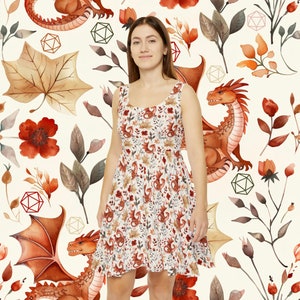 May include: A white dress with a red, orange and brown dragon and floral pattern. The dress has a scoop neck and a sleeveless design.