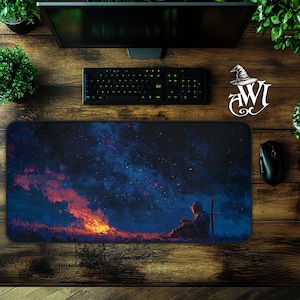 Könnte beinhalten: Rechteckiges Mauspads mit einem digitalen Gemälde eines Ritters, der neben einem Lagerfeuer unter einem Sternenhimmel sitzt. Die Farbpalette umfasst Blau-, Orange- und Schwarztöne. Eine Tastatur, eine Maus und ein Monitor sind sichtbar.