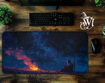 May include: A rectangular mouse pad featuring a digital painting of a knight sitting near a campfire under a starry sky. The color palette includes shades of blue, orange, and black. A keyboard, mouse, and monitor are visible.