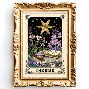 May include: A gold framed print of a tarot card depicting The Star. The card features a large, five-pointed star with a yellow outline and a black interior. The star is surrounded by a dark blue background with small white stars. The card also features a book with a red spine and a few flowers in purple, pink, and white.