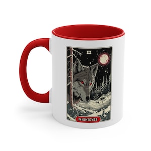 May include: White ceramic mug with a red interior and a wolf illustration. The wolf has red eyes and is surrounded by a dark forest and a full moon. The text "NIGHTEYES" is printed below the image.