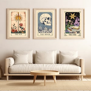 May include: Three tarot card prints with illustrations of The Sun, The Moon, and The Star. Each print has a white background with a gold frame and the name of the card printed below the image.