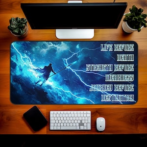 May include: A blue and black mousepad with a silhouette of a person holding a spear standing in front of a lightning storm. The text "LIFE BEFORE DEATH, STRENGTH BEFORE WEAKNESS, JOURNEY BEFORE DESTINATION" is printed on the right side of the mousepad.