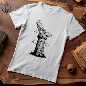 Könnte beinhalten: Weißes T-Shirt mit einer Schwarz-Weiß-Illustration eines brennenden mittelalterlichen Turms. Der Turm ist mit Fenstern und Zinnen detailliert, mit Rauch, der aus der Spitze quillt. Das Design beinhaltet stilisierte Wolken.