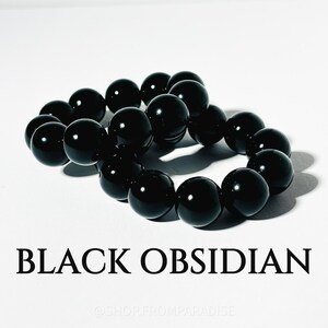 May include: Two strands of black obsidian beads, each strand is a bracelet with 10 beads. The beads are round and smooth.