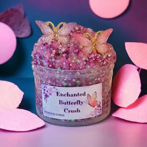 May include: A clear jar filled with pink and purple glitter slime with two gold butterfly charms on top. The jar has a label that reads "Enchanted Butterfly Crush" and "Fuzzyslimes".