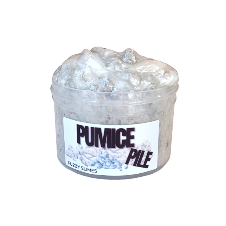 May include: A clear plastic container filled with a light gray slime with white and gray rocks mixed in. The container has a white label that says "PUMICE PILE" and "FUZZY SLIMES".