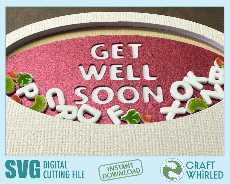 Op de afbeelding: Een roze ovale kaart met de woorden "Get Well Soon" uitgesneden. Witte schuimletters zijn rond de kaart verspreid, samen met groene en oranje viltvormen.