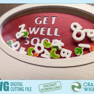 Op de afbeelding: Een rode kaart met een witte ovale uitsparing. De ovale is gevuld met witte letters die "GET WELL SOON" spellen en met groene en witte confetti. De kaart is omgeven door een witte rand.