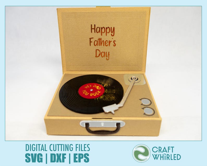 Puede incluir: Una caja beige abierta que se asemeja a un tocadiscos vintage, con las palabras "Happy Father's Day" en la cubierta interior. Un disco de vinilo negro con detalles en rojo y amarillo est&aacute; en el tocadiscos. El texto "HEY DAD YOU ROCK" est&aacute; en el disco.