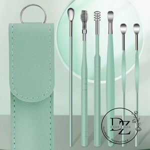 May include: Set of six green ear cleaning tools with a spiral, a pointed tip, and a rounded tip. The tools come in a green leather case with a silver ring.