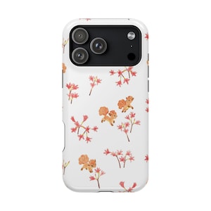 Puede incluir: Funda de teléfono blanca con un patrón repetido de ardillas de dibujos animados y flores rosas. La funda tiene un módulo de cámara negro con tres lentes. El diseño es caprichoso e inspirado en la naturaleza.