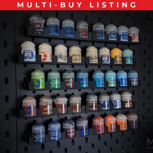 May include: A black pegboard display unit with several shelves filled with paint pots in various colours. The paint pots are arranged on shelves. The text "MULTI-BUY LISTING" is at the top.