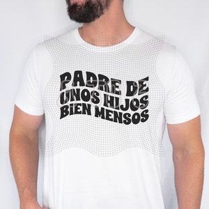 May include: White t-shirt with the text "PADRE DE UNOS HIJOS BIEN MENSOS" in black, bold, retro-style font. The shirt is a classic crew neck style.