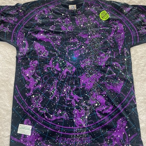 May include: A black t-shirt with a purple and blue constellation print. The shirt has a "Glow in the Dark" label and the text "Hemisphere Bor&eacute;al" at the bottom.