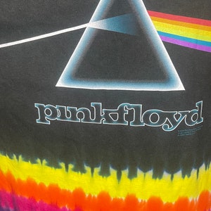 May include: Black tie-dye t-shirt with a white triangle and rainbow prism graphic. The text "pink floyd" is printed below the graphic.