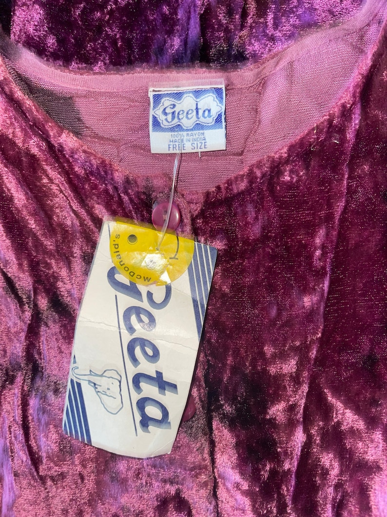 May include: A purple velvet robe with a white tag that says "Geeta 100% Rayon Made in India Free Size".