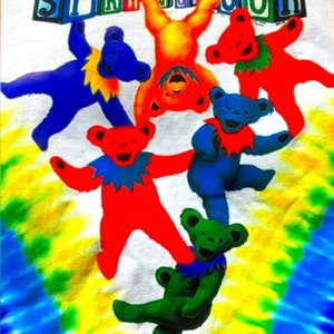 Puede incluir: Una camiseta tie-dye con un gr&aacute;fico colorido de osos bailando sosteniendo la palabra "SPRINGTOUR".