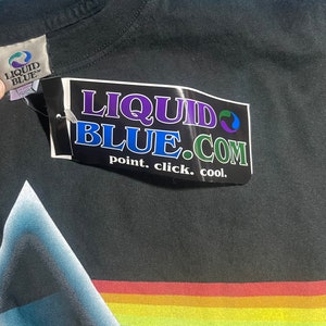 May include: Black t-shirt with a rainbow stripe design and a Liquid Blue tag. The tag says "point. click. cool."