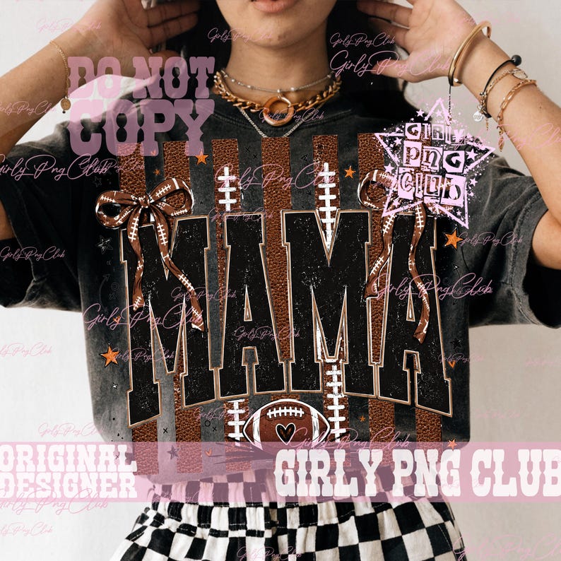 May include: A black mineral-washed t-shirt featuring the word MAMA in large black block letters with a brown football texture background. The design includes two brown football-patterned bows, white football laces, and a football graphic.
