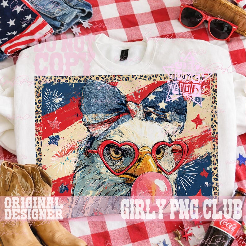 May include: White crewneck sweatshirt featuring a graphic of an eagle wearing heart-shaped glasses and a patriotic bow. The eagle is blowing a bubblegum bubble. The background has a red, white, and blue American flag design.